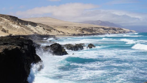 small waves crashing against rocks in canarias