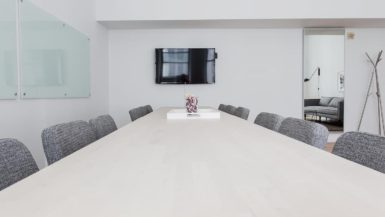A convention room with chairs, a table and a television.