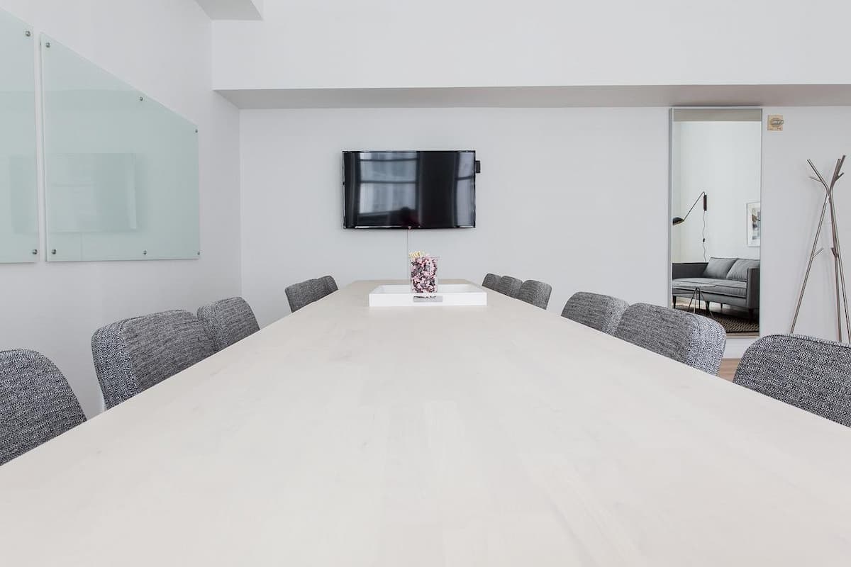 A convention room with chairs, a table and a television.