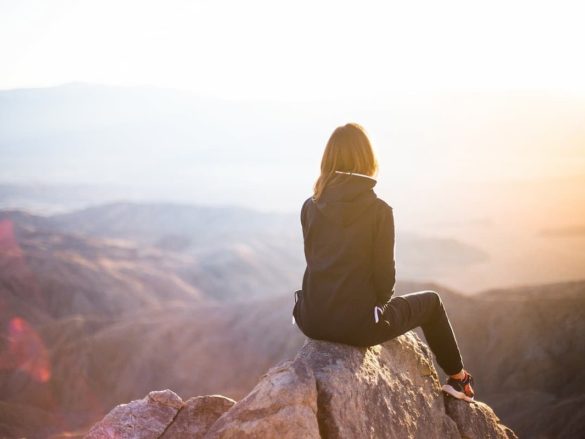 A woman at the peak of a mountain watching around her