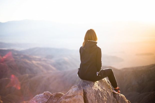 A woman at the peak of a mountain watching around her