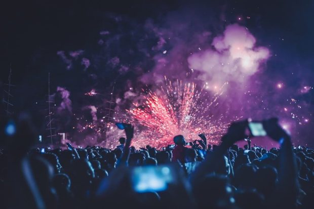 Personas celebrando y grabando vídeos en un festival