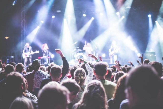 Personas alzando la mano en un concierto