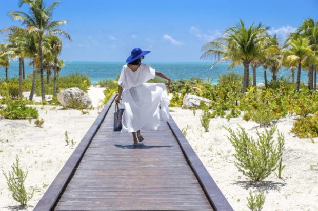 Mujer caminando por la playa cerca de un hotel catalonia