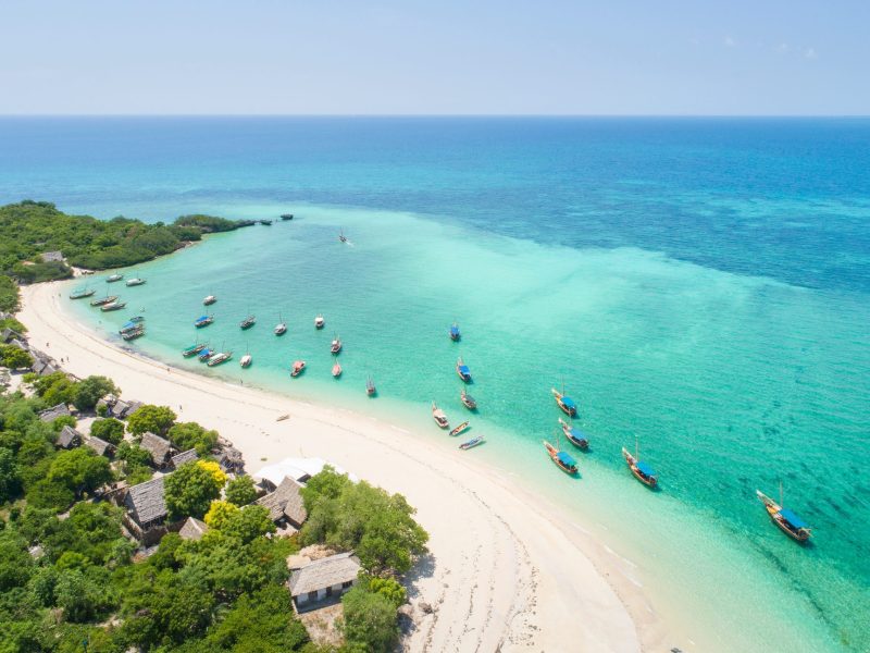curved coast and beautiful beach with boats on Zanzibar island