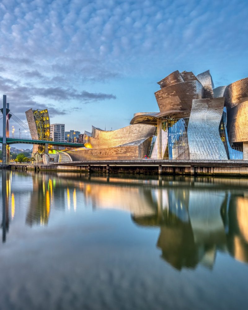 BILBAO, SPAIN - July 10, 2021: The futuristic Guggenheim Museum reflected in the River Nervion before sunrise