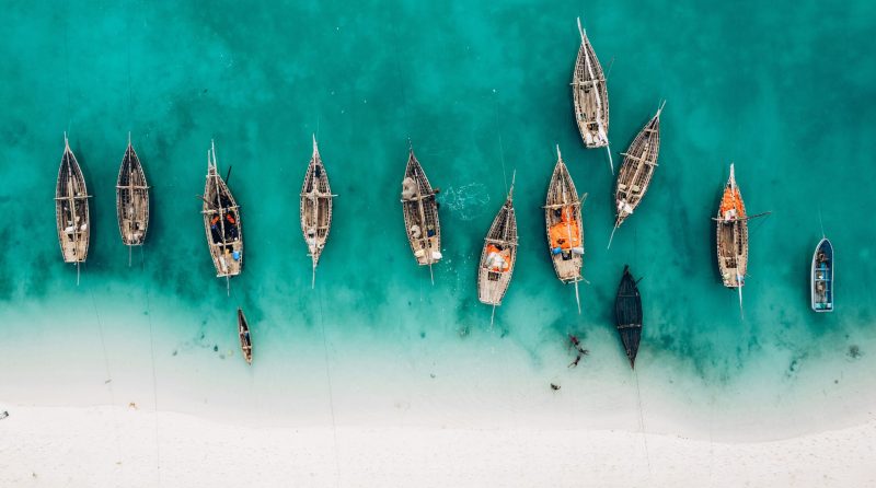 Top view or aerial view of Beautiful crystal clear water and white beach with long tail boats in summer of Zanzibar island
